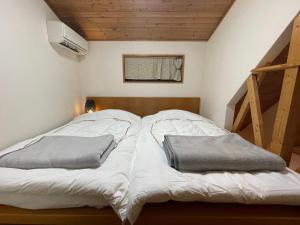 1 cama con 2 almohadas en una habitación en 白浜ホープヒルズ　G-60 en Shirahama