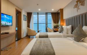 Grand Gosia Hotel في نها ترانغ: غرفة فندقية بسريرين وتلفزيون بشاشة مسطحة
