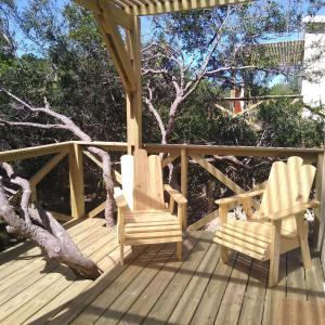 2 sillas en una terraza de madera con un árbol en Nio de Baixo, en La Pedrera