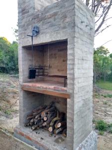 un horno de ladrillo con un montón de troncos en él en Nio de Baixo, en La Pedrera