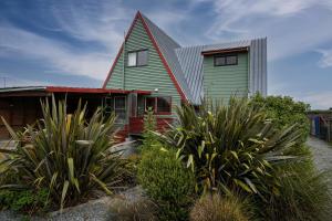 uma casa verde e vermelha com um telhado vermelho em Snow Chalet - Fairlie Holiday Home em Fairlie