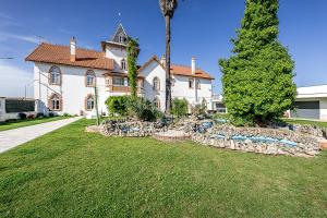 a house with a palm tree in front of it at Garden Apartment Dona Amélia in Abrantes