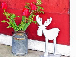 a statue of a deer next to a vase of roses at 3 person holiday home in Tystberga in Tystberga
