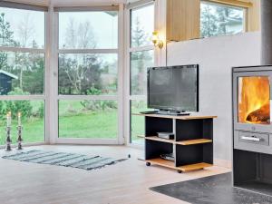 een woonkamer met een tv en een open haard bij 8 person holiday home in S by in Sæby