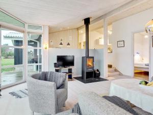 een woonkamer met een open haard en een televisie bij 8 person holiday home in S by in Sæby