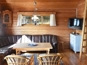 a living room with a leather couch and a table at 6 person holiday home in Bud-By Traum in Bud