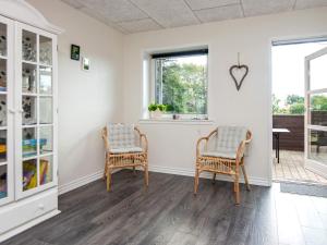 2 sillas en una habitación con paredes y ventanas blancas en 8 person holiday home in Ringk bing en Ringkøbing
