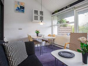 een woonkamer met een tafel en stoelen bij 6 person holiday home in V ggerl se in Bøtø By