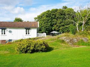 a white house on a hill next to a field at 5 person holiday home in FISKEB CKSKIL in Fiskebäckskil