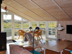 a living room with a couch and a table and chairs at 6 person holiday home in Fan in Fanø