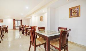 uma sala de jantar com mesa e cadeiras em Treebo Trend Symphony Hotels And Resorts Angamally em Kizhake Chālakudi