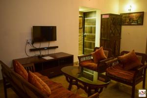 een woonkamer met 2 banken en een tv bij Swaru Luxurious Villa in Tamhini Ghat & Kolad Rafting in Nizāmpur