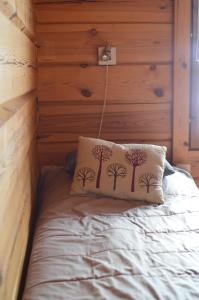 Una cama con una almohada con árboles. en Turjanlinna, en Rantasalmi