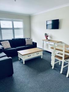 a living room with a blue couch and a coffee table at The Astor Hotel Motel in Goulburn