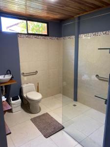 a bathroom with a toilet and a glass shower at MâpleTico Casita in Monteverde Costa Rica