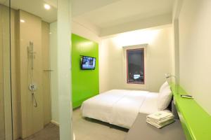 Un pat sau paturi într-o cameră la POP! Hotel Diponegoro