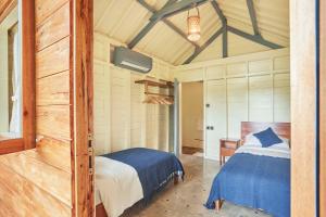 een slaapkamer met 2 bedden in een kamer bij House of Sawah in Batukaras