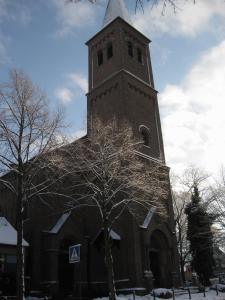 una iglesia con un campanario alto con un árbol delante en Hotel Matheisen en Colonia