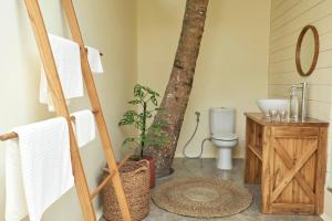 a bathroom with a sink and a toilet and a tree at House of Sawah in Batukaras