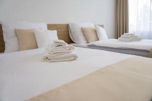 duas camas brancas com toalhas por cima em Wellness hotel Mestská plaváreň em Trebišov