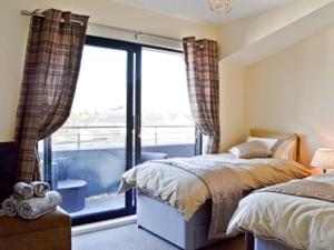 
a bedroom with a bed and a window at The Penthouse- The Kingsley Collection in Troon
