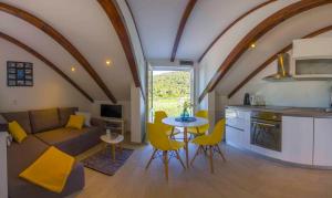 ein Wohnzimmer mit einem Sofa, einem Tisch und gelben Stühlen in der Unterkunft Apartments Filip - vineyard and large terrace in Vis
