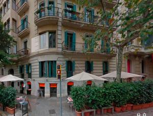 バルセロナにあるブルック＆ブルックの建物の前にテーブルと傘