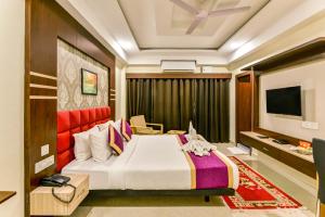 een hotelkamer met een bed en een televisie bij Mount Amara Hotel & Spa, Siliguri in Siliguri