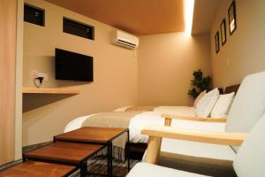 a hotel room with two beds and a tv at Liaison Court Nishikujo Universal Bay in Osaka