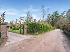 a dirt road with a fence and a hedge at Scenic holiay home in Merksplas with garden in Merksplas