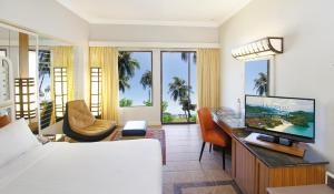 Holiday Villa Resort & Beachclub Langkawi في بانتايْ سينانج: غرفه فندقيه سرير وتلفزيون