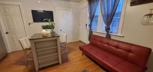 a living room with a red couch and a table at Cozy 1 bedroom, 1 min from Irving Park Blue line, free parking in Chicago
