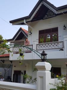 a woman sitting on the balcony of a house at Hotel Barbara Villa in Kalutara