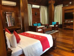 a bedroom with a bed and a desk and chairs at Try Palace Resort Kep in Kep