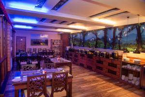 a restaurant with tables and chairs in a room at Chamong Chiabari Mountain Retreat in Darjeeling