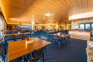 un restaurant avec des plafonds en bois, des tables et des chaises dans l'établissement Carnarvon Motel, à Carnarvon