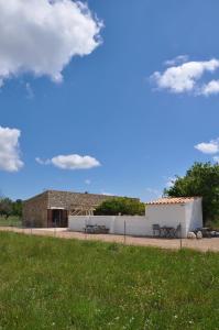 a building with a bench in front of a grass field at Ca'n Guiri, Eco Finca in Mallorca in Campanet