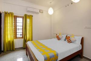 1 dormitorio con 1 cama grande y cortinas amarillas en Retaj Residency en Ernakulam