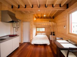 a bedroom with a bed in a wooden house at Brick House Furano in Furano