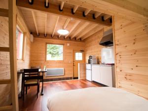 a bedroom with a bed and a table in a room at Brick House Furano in Furano