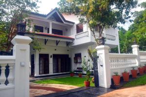 a white house with a courtyard with plants at Hotel Barbara Villa in Kalutara