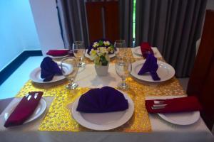 a table with plates and hats on top of it at Hotel Barbara Villa in Kalutara