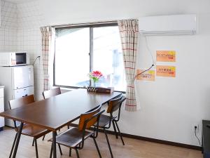 a dining room with a table and chairs and a window at Calm house Beppumotomachi in Beppu
