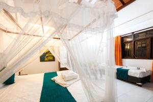 - une chambre avec un lit à baldaquin dans l'établissement Prime Time Hotel, à Unawatuna