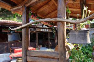 a restaurant with two bells hanging from a wooden structure at Family Hotel Dinchova kushta in Rozhen