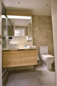 a bathroom with a sink and a toilet and a mirror at Baron Boutique Hotel Yerevan in Yerevan