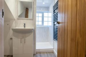 a bathroom with a sink and a shower at Gloucester-Modernised 4 Bedroom Cottage-Sleeps 8-Free Parking-Fast Wi-Fi in Gloucester +52 photos