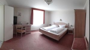 a bedroom with a bed and a desk and a window at Hotel Am Markt in Arnsberg