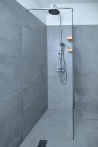 eine Dusche mit Glastür im Bad in der Unterkunft Larissa city center appartment ολοκαίνουργιο κομψό in Larisa