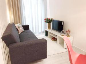 a living room with a couch and a tv at Casa Suyay Studio in Aveiro